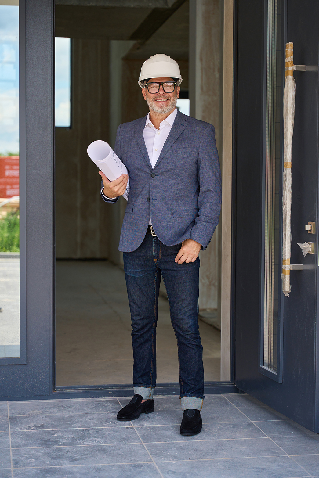 Entrepreneur confiant devant un chantier de maison à ossature bois